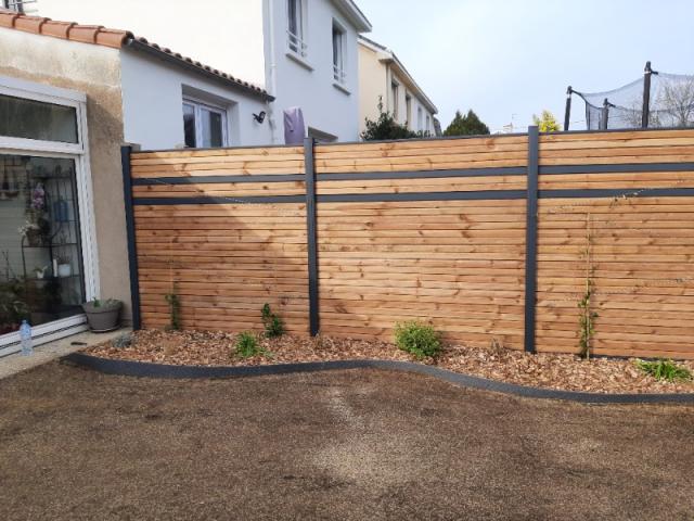 Alliance de style : clôture bois et poteaux alu pour vos extérieurs