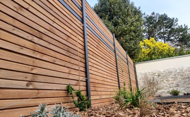 Alliance de style : clôture bois et poteaux alu pour vos extérieurs